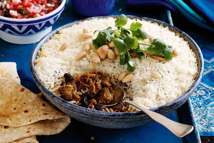Cooking Meat Beef biryani with caramelised onions and almonds