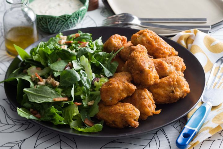 Cooking Meat Buffalo wings with blue cheese sauce and chopped salad