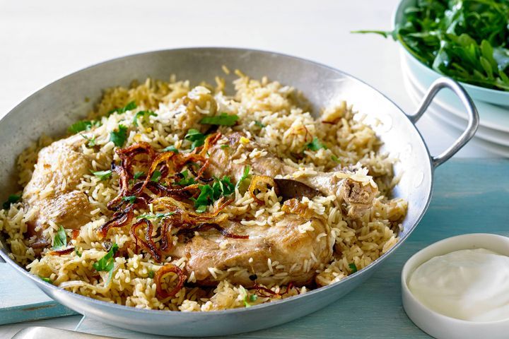 Cooking Meat Indian spiced rice with chicken, crispy onions and saffron