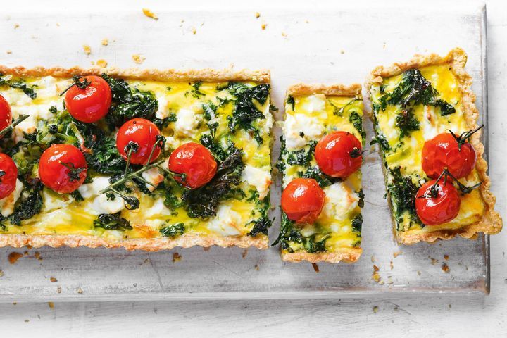 Cooking Vegetarian Wholemeal quiche with wilted kale and tomatoes