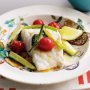 Baked fish with tomato, zucchini and potato wedges